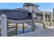 View of a boat on a boat lift, covered with a black tarp to protect from the elements at 13313 Gasparilla Rd # 404, Placida, FL 33946