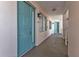 Hallway with teal doors, neutral walls, and access to residences in a condominium building at 13313 Gasparilla Rd # 404, Placida, FL 33946