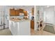 Open kitchen with wood cabinets, bar seating, and seamless flow into the entry at 13313 Gasparilla Rd # 404, Placida, FL 33946