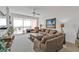 Bright living room with comfortable seating and sliding glass doors to the balcony with water view at 13313 Gasparilla Rd # 404, Placida, FL 33946