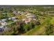 Aerial shot showcasing the house in a tranquil community with mature trees and open green spaces at 1332 Hedgewood Cir, North Port, FL 34288