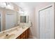 Bathroom offers double sinks with a large mirror, as well as a white closet with paneled doors at 1332 Hedgewood Cir, North Port, FL 34288