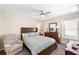 Neutral bedroom featuring a queen bed, ceiling fan, dresser, and a window with natural light at 1332 Hedgewood Cir, North Port, FL 34288