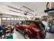 Spacious garage with a red SUV parked inside with ample storage and tools at 1332 Hedgewood Cir, North Port, FL 34288