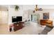 Open-concept living area features bar seating, TV area, and view of lanai through sliding doors at 1332 Hedgewood Cir, North Port, FL 34288