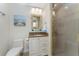 Bathroom with a vanity, decorative mirror, toilet, and a glass-enclosed shower with tiled walls at 1410 Beach Rd # 201, Englewood, FL 34223