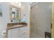 Bathroom with a vanity, decorative mirror, toilet, and a glass-enclosed shower with tiled walls at 1410 Beach Rd # 201, Englewood, FL 34223