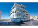 Beautiful low-rise condo building featuring multiple balconies, bright blue siding, and two garage doors at 1410 Beach Rd # 201, Englewood, FL 34223