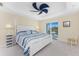 Beautiful main bedroom features a bed, a tray ceiling, a decorative ceiling fan and balcony access at 1410 Beach Rd # 201, Englewood, FL 34223