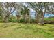 Manicured backyard featuring shady trees and lush landscaping at 14298 Reserve Ct, Port Charlotte, FL 33953