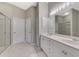 Bright bathroom featuring double vanity, large mirror, and glass-enclosed shower at 14298 Reserve Ct, Port Charlotte, FL 33953