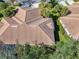 Aerial view featuring a well-maintained tile roof and lush landscaping surrounding the property at 14298 Reserve Ct, Port Charlotte, FL 33953