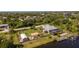 Stunning aerial view of a waterfront property with a private dock, pool, and beautifully landscaped yard at 14382 Lillian Cir, Port Charlotte, FL 33981