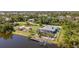 Aerial view of waterfront home with a private dock, lush backyard and covered patio at 14382 Lillian Cir, Port Charlotte, FL 33981