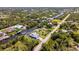 Aerial view of home nestled on canal with private dock, mature trees, and nearby neighborhood at 14382 Lillian Cir, Port Charlotte, FL 33981