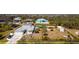 Aerial view showcases the property's layout, including the home, yard, and waterfront location in a neighborhood at 14382 Lillian Cir, Port Charlotte, FL 33981