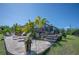 A view of the brick patio, including the screened enclosure, tropical plants, and outdoor furniture at 14382 Lillian Cir, Port Charlotte, FL 33981