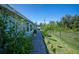 A view of the side yard with brick pavers, garden beds, and a privacy fence at 14382 Lillian Cir, Port Charlotte, FL 33981