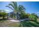 Landscaped backyard with palm trees, paved walkway, and fenced perimeter at 14382 Lillian Cir, Port Charlotte, FL 33981