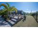 Landscaped backyard featuring a screened lanai with outdoor seating and mature palms at 14382 Lillian Cir, Port Charlotte, FL 33981