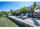 Relaxing backyard retreat with screened lanai, sun loungers, and lush palm trees at 14382 Lillian Cir, Port Charlotte, FL 33981