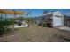 Cozy backyard featuring a detached garage, patio, and pergola ideal for outdoor relaxation and entertainment at 14382 Lillian Cir, Port Charlotte, FL 33981