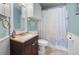 Well-lit bathroom features a wood vanity, updated fixtures, and a shower with leaf-patterned curtain at 14382 Lillian Cir, Port Charlotte, FL 33981