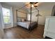 Bedroom with a four poster bed, hardwood floors, and a large window at 14382 Lillian Cir, Port Charlotte, FL 33981