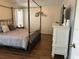 Bedroom with hardwood floors, a four poster bed, and a white dresser at 14382 Lillian Cir, Port Charlotte, FL 33981