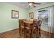 Dining room with view of pool area, wooden table, 6 chairs, ceiling fan and laminate wood flooring at 14382 Lillian Cir, Port Charlotte, FL 33981