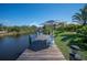 Scenic dock view with seating and umbrella on the water, offering a relaxing outdoor space at 14382 Lillian Cir, Port Charlotte, FL 33981