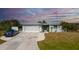 Charming one-story home with a well-manicured lawn, two car garage, and an American flag flying proudly at 14382 Lillian Cir, Port Charlotte, FL 33981