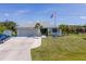 Charming single-story home featuring a well-maintained lawn, two-car garage, and an American flag at 14382 Lillian Cir, Port Charlotte, FL 33981