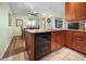 Bright kitchen featuring granite countertops, wooden cabinets, stainless steel appliances, and an adjacent dining area at 14382 Lillian Cir, Port Charlotte, FL 33981