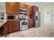 Modern kitchen with stainless steel appliances, wood cabinets, granite countertops, and tile backsplash at 14382 Lillian Cir, Port Charlotte, FL 33981