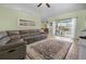 Bright living room featuring tile floors, a large sectional, and sliding doors that lead to an outdoor pool at 14382 Lillian Cir, Port Charlotte, FL 33981