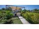 A covered patio with a dining set and lush greenery, perfect for outdoor entertaining at 14382 Lillian Cir, Port Charlotte, FL 33981