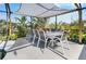Covered outdoor dining area with seating for ten amidst lush landscaping at 14382 Lillian Cir, Port Charlotte, FL 33981