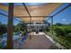 Covered patio area featuring an outdoor dining set and a view of the manicured yard at 14382 Lillian Cir, Port Charlotte, FL 33981