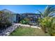 Screened patio and walkway surrounded by beautiful plants and flowers, offering a tranquil outdoor space at 14382 Lillian Cir, Port Charlotte, FL 33981