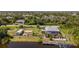 Waterfront home boasts an outdoor patio, private dock, boat lift, storage shed, and a covered outdoor seating area at 14382 Lillian Cir, Port Charlotte, FL 33981