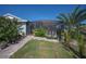 The screened patio is surrounded by lush landscaping and a charming stone walkway at 14382 Lillian Cir, Port Charlotte, FL 33981