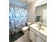 Bathroom with a patterned shower curtain, toilet, and cabinet sink at 14399 Morristown Ave, Port Charlotte, FL 33981