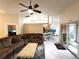 Cozy living room with sectional sofa, ceiling fan, and an open floor plan to the kitchen and lanai at 14399 Morristown Ave, Port Charlotte, FL 33981