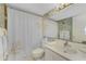 Cozy bathroom featuring a shower and tub, white vanity, and a decorative mirror at 1461 Aqui Esta Dr # B3, Punta Gorda, FL 33950