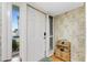 Bright and airy entryway with white door, leafy wallpaper, and a charming wicker shelf at 1461 Aqui Esta Dr # B3, Punta Gorda, FL 33950