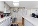 Bright kitchen with white appliances, light wood floor, and patterned wallpaper at 1461 Aqui Esta Dr # B3, Punta Gorda, FL 33950