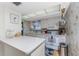 Bright kitchen features white appliances, skylight, ample counter space and patterned wallpaper at 1461 Aqui Esta Dr # B3, Punta Gorda, FL 33950