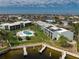 Aerial view of condo complex featuring a kidney-shaped pool, well-maintained landscaping, and private boat docks at 1461 Aqui Esta Dr # B3, Punta Gorda, FL 33950