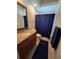 Bathroom features granite countertop, wood cabinets, and a shower with a blue curtain at 14970 Appleton Blvd, Port Charlotte, FL 33981